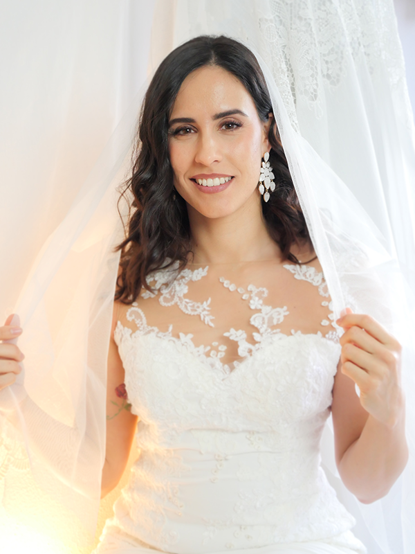 Novia sonriendo con su vestido y velo el día de su boda